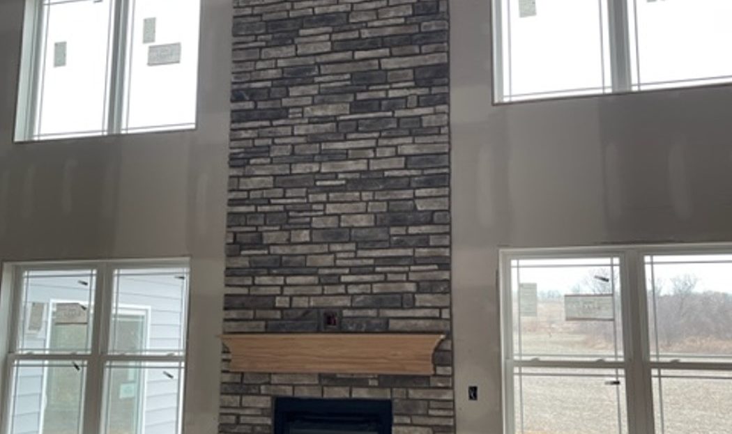 under construction, drywall finish, fireplace with stone to ceiling